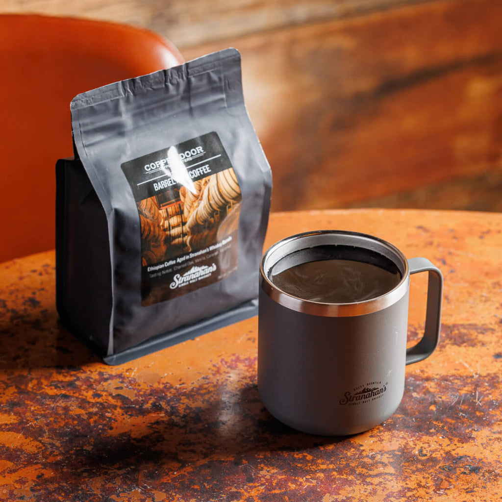 Overhead shot of Stranahan's Barrel aged coffee packaging paired with a gray Stranahan's mug