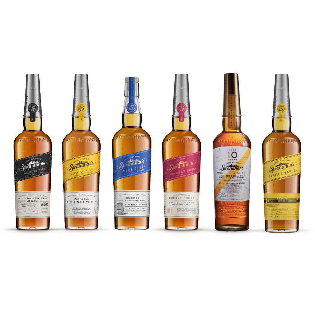 Six bottles of Stranahan's whiskey, including Original, Blue Peak, Single Barrel, and finishes like Solera and Sherry Cask, displayed in a row.