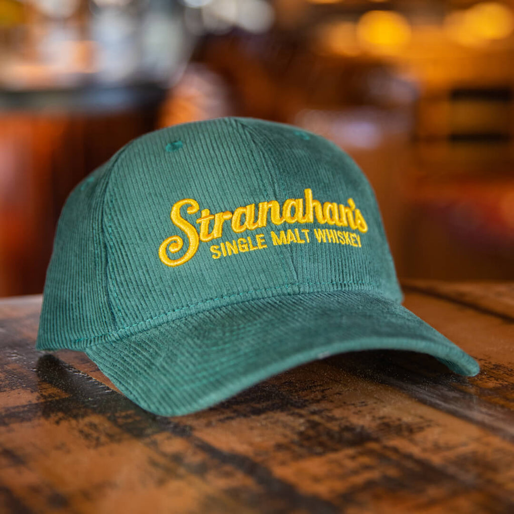 Stranahan's Green Corduroy Hat on wooden surface