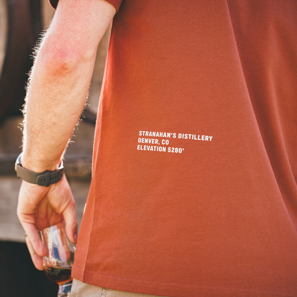 Rear view of Stranahan's Handcrafted at High Altitude Tee showing Denver Distillery location elevation