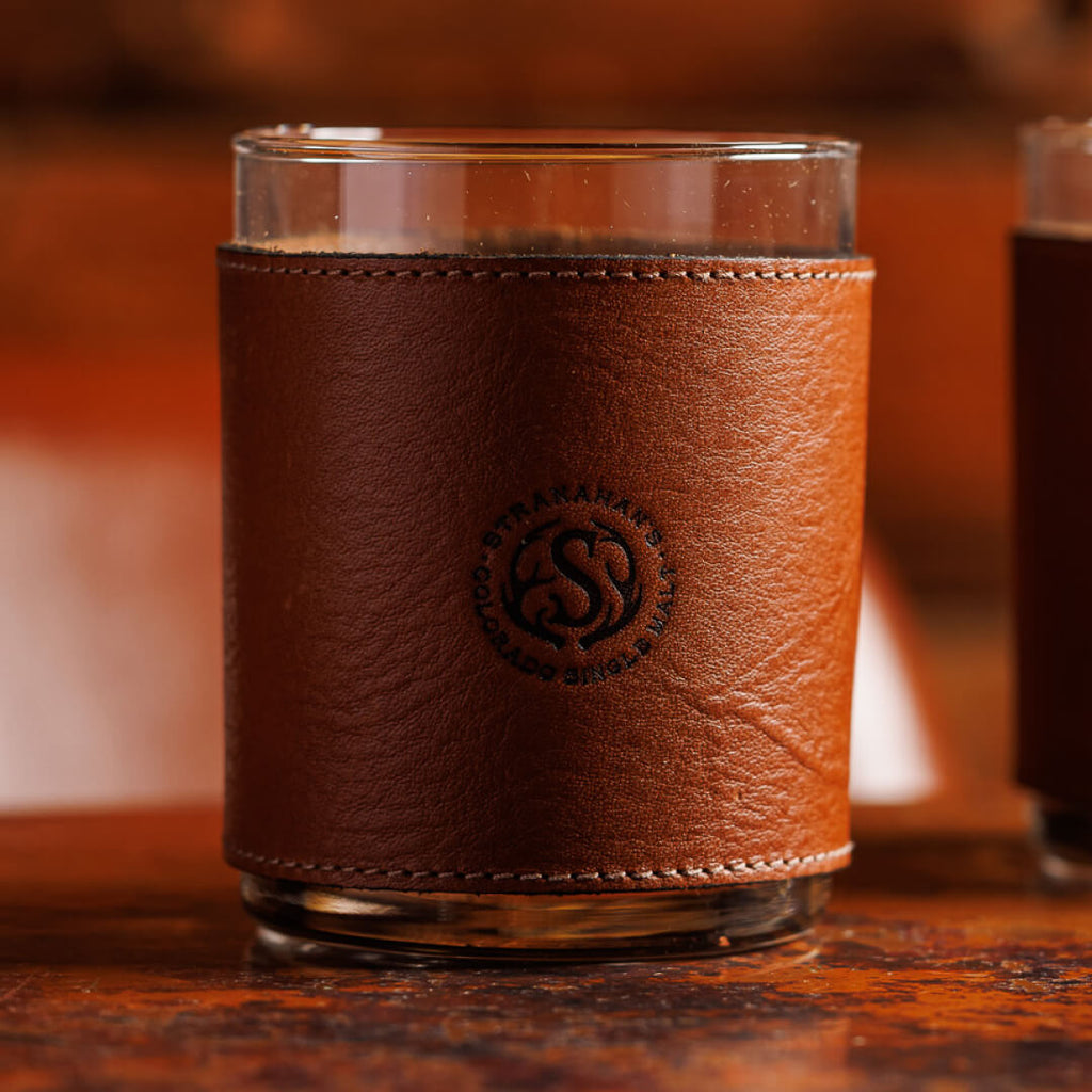 Closeup of leather wrapped tumbler glasses stamped with the Stranahan's logo