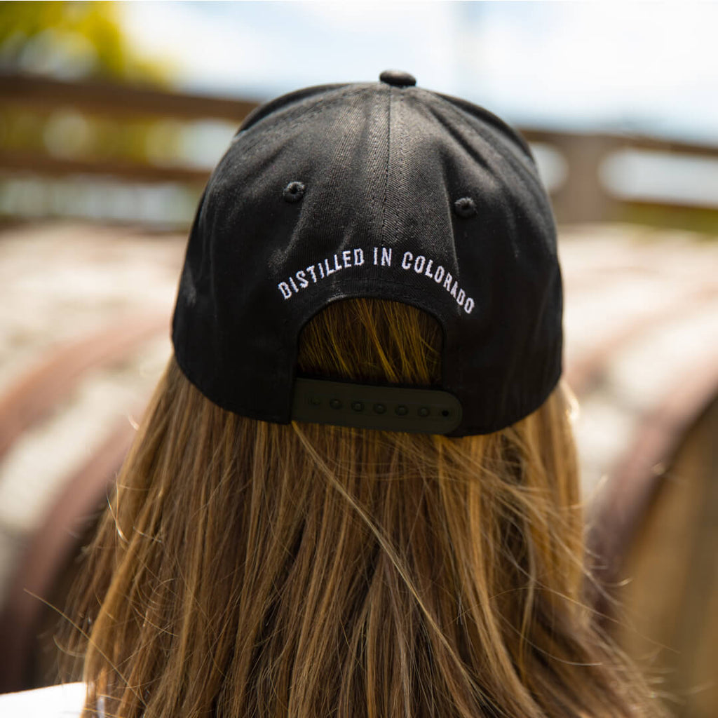Rear facing view of Stranahan's Mountain Pride Hat with "Distilled In Colorado" embroidery