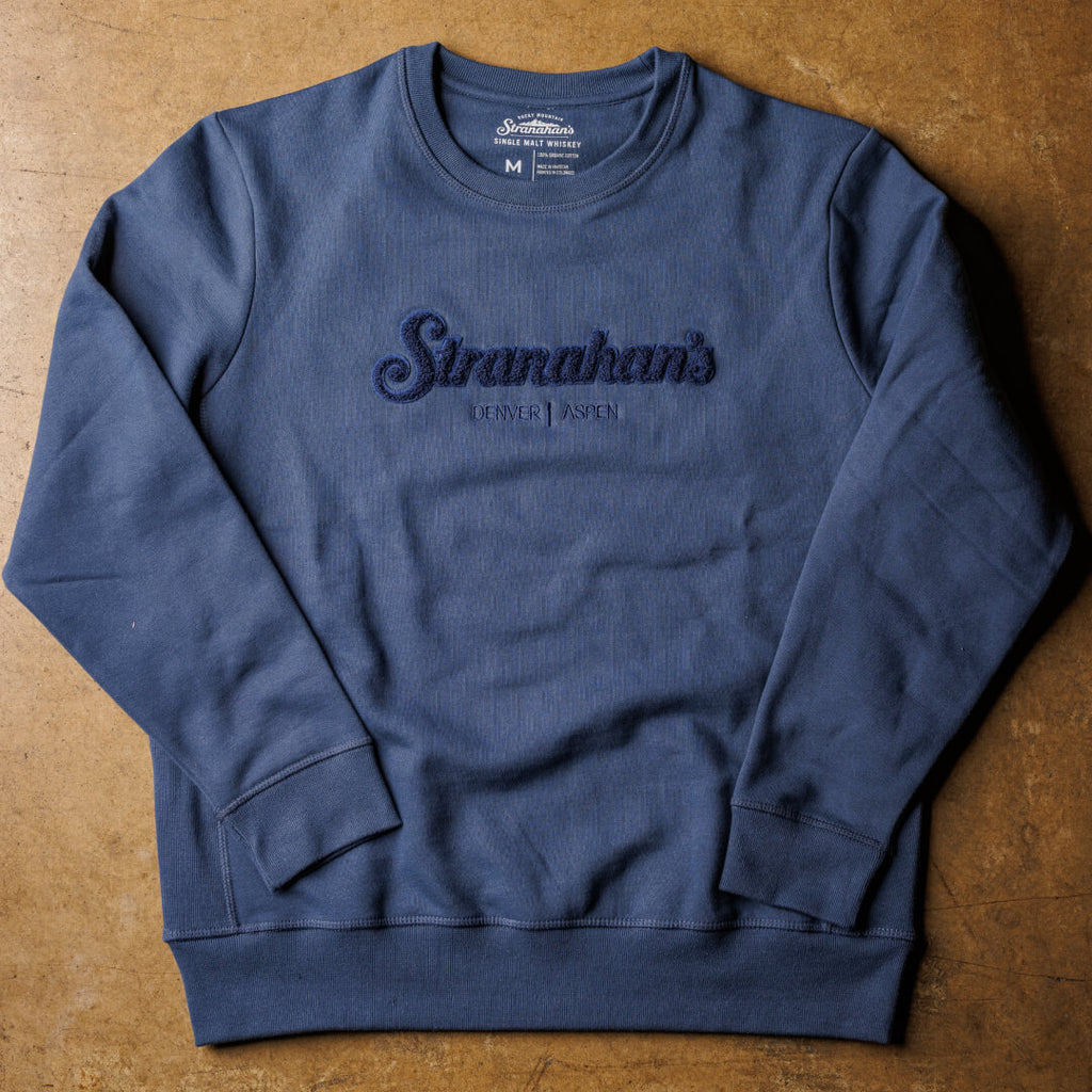 Flatlay view of navy sweatshirt with chenille Stranahan's patch