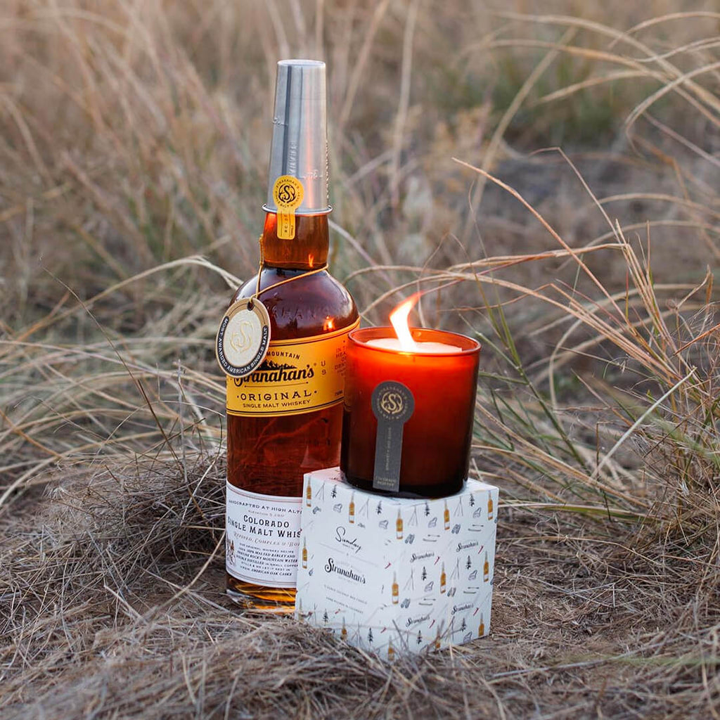 Stranahan's X Sunday Candle Co. Colorado Reserve Candle in amber glass vessel next to a bottle of Stranahan's Original