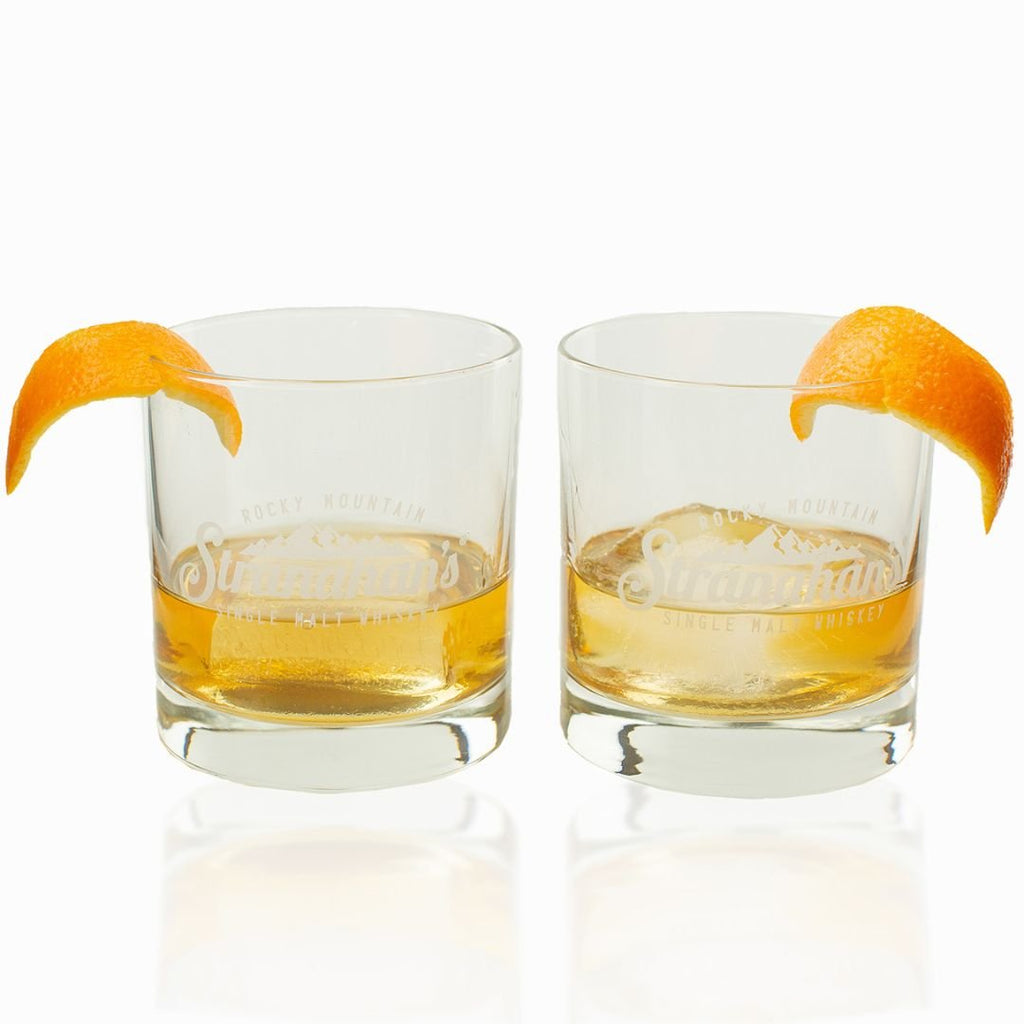 Two glasses of Stranahan's Whiskey with orange peel garnish, featuring the Rocky Mountain Stranahan's logo.