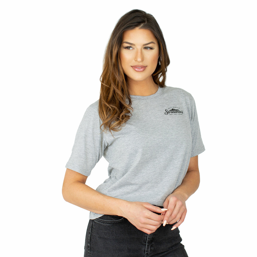 Front view of female model wearing a grey Stranahan's barrel truck tee.