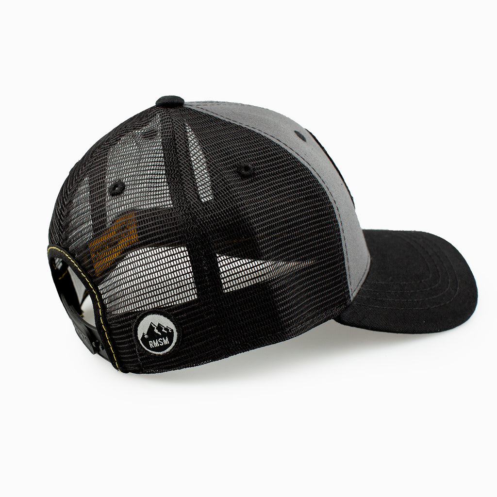 Side view of grey and black trucker hat with yellow Stranahan's logo.