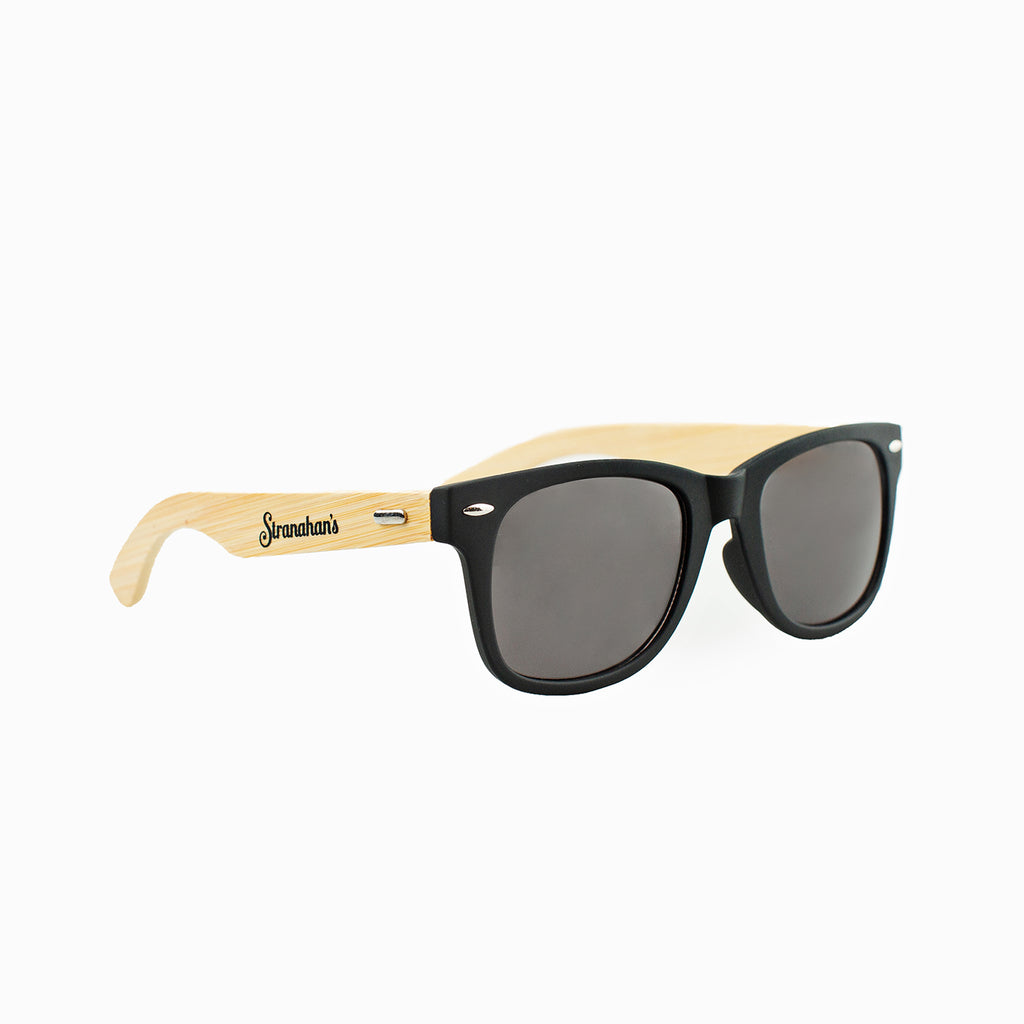 Front view of wood stemmed sunglasses with Stranahan's logo and black lenses.