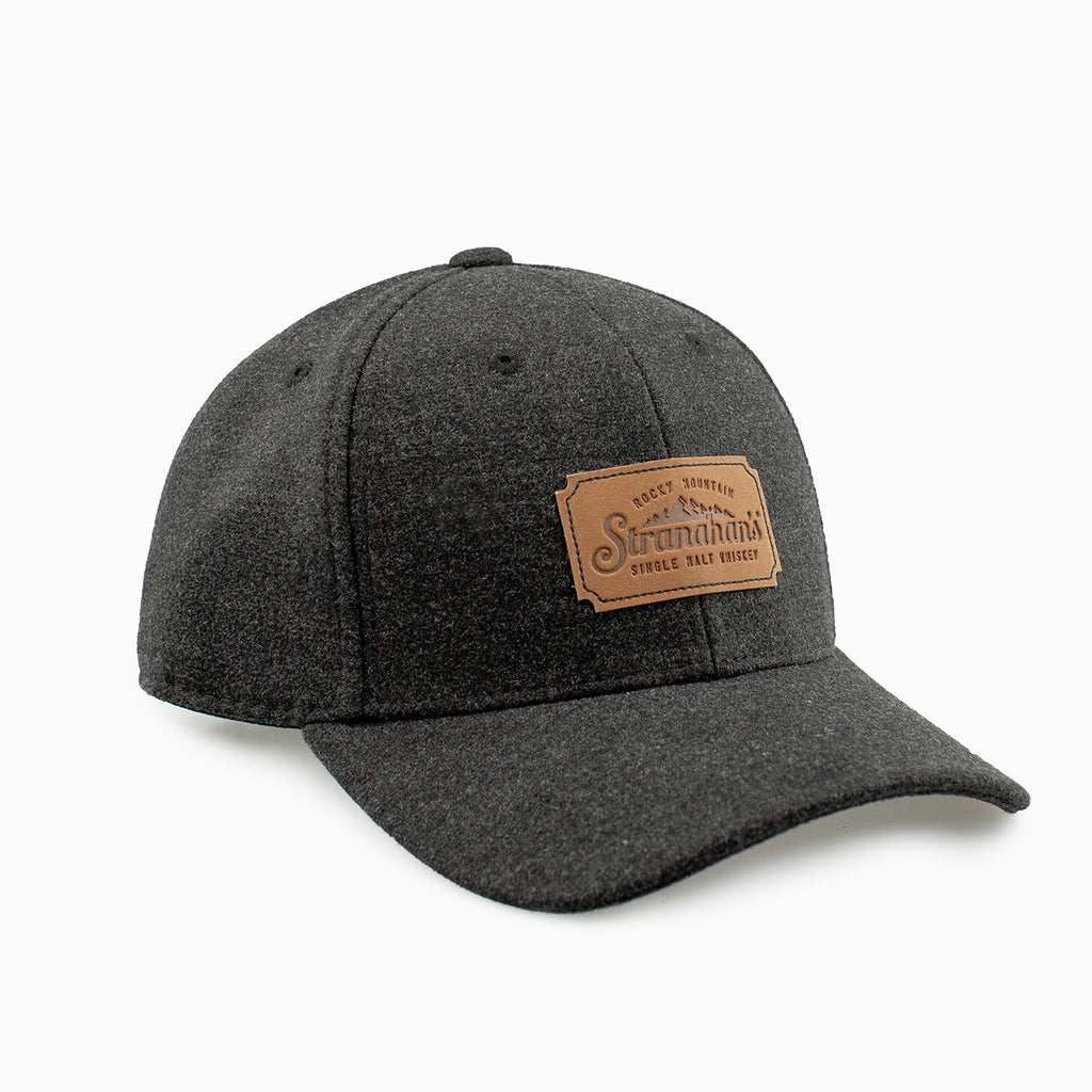Front view of dark grey wool cap with leather Stranahan's logo.