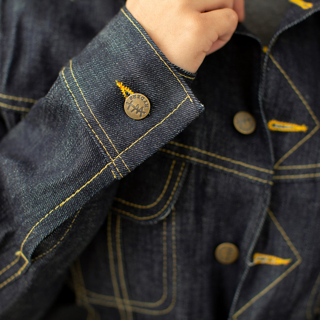 Close up of button details on Stranahan's denim jacket on female model.